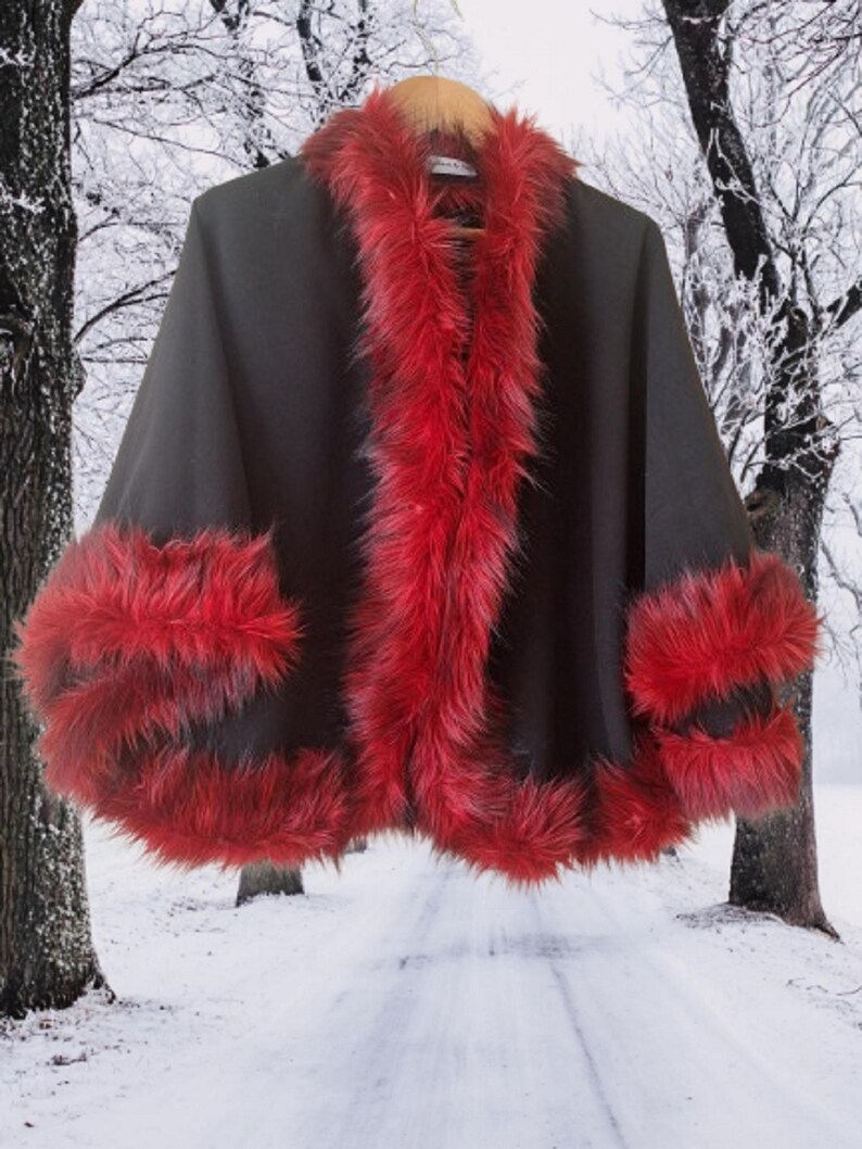 Luxury handmade black alpaca & wool cape jacket with soft vegan red fur trim, designed for comfort and dramatic flair during the cold season.”