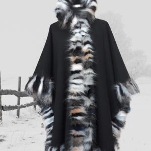 “Front angled view of a hooded black cashmere wool cape with dramatic multicolor  fur trim, blending modern luxury with classic winter charm.”