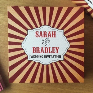 May include: A red and white striped wedding invitation with a white banner that says "Sarah and Bradley Wedding Invitation".