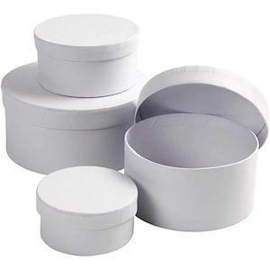May include: Set of four white round cardboard gift boxes of varying sizes. The boxes are stacked on top of each other.