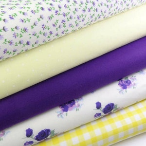 May include: A stack of five fabric swatches in various patterns and colors. The top swatch is white with a small purple floral print. The second swatch is a pale yellow with white polka dots. The third swatch is a solid purple. The fourth swatch is white with a larger purple floral print. The bottom swatch is a yellow and white gingham pattern.