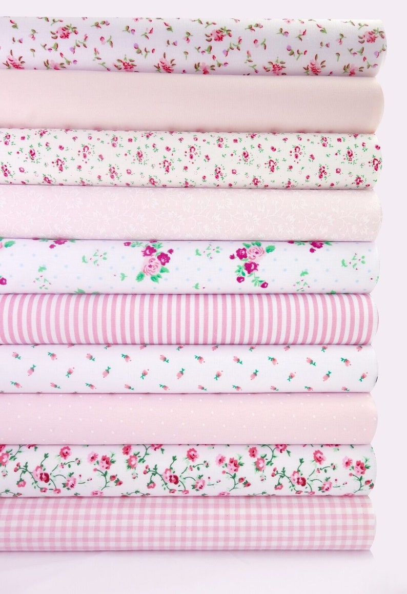 May include: A stack of pink fabric with various patterns, including floral, polka dot, gingham, and stripes.
