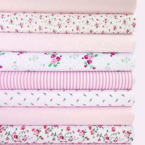 May include: A stack of pink fabric with various patterns, including floral, polka dot, gingham, and stripes.