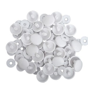 May include: A pile of white plastic snap fasteners, also known as press studs or poppers. These fasteners are commonly used for clothing, crafts, and other projects.
