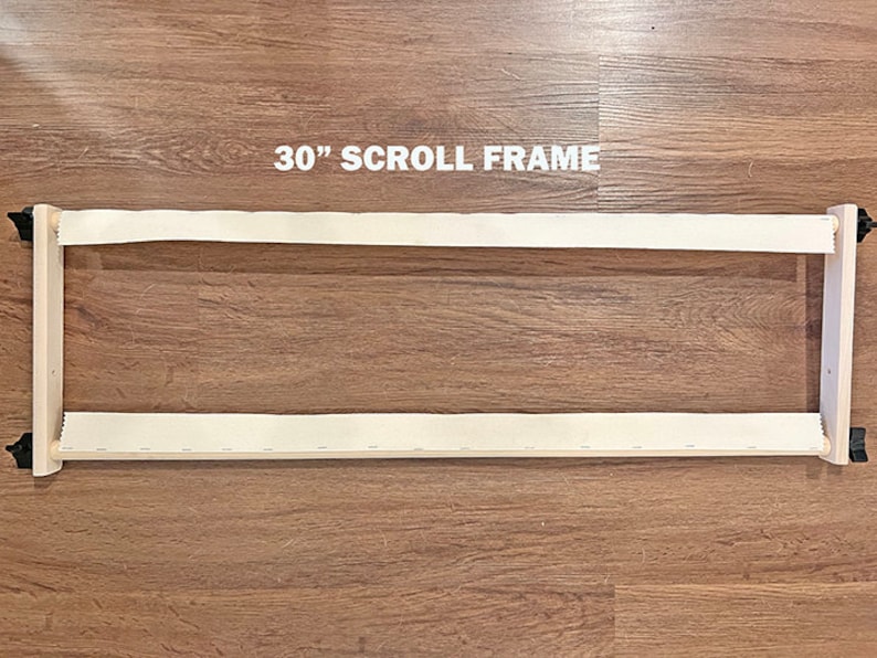 May include: A 30-inch wooden scroll frame with white canvas stretched across it. The frame is made of natural wood and has black knobs on each end.