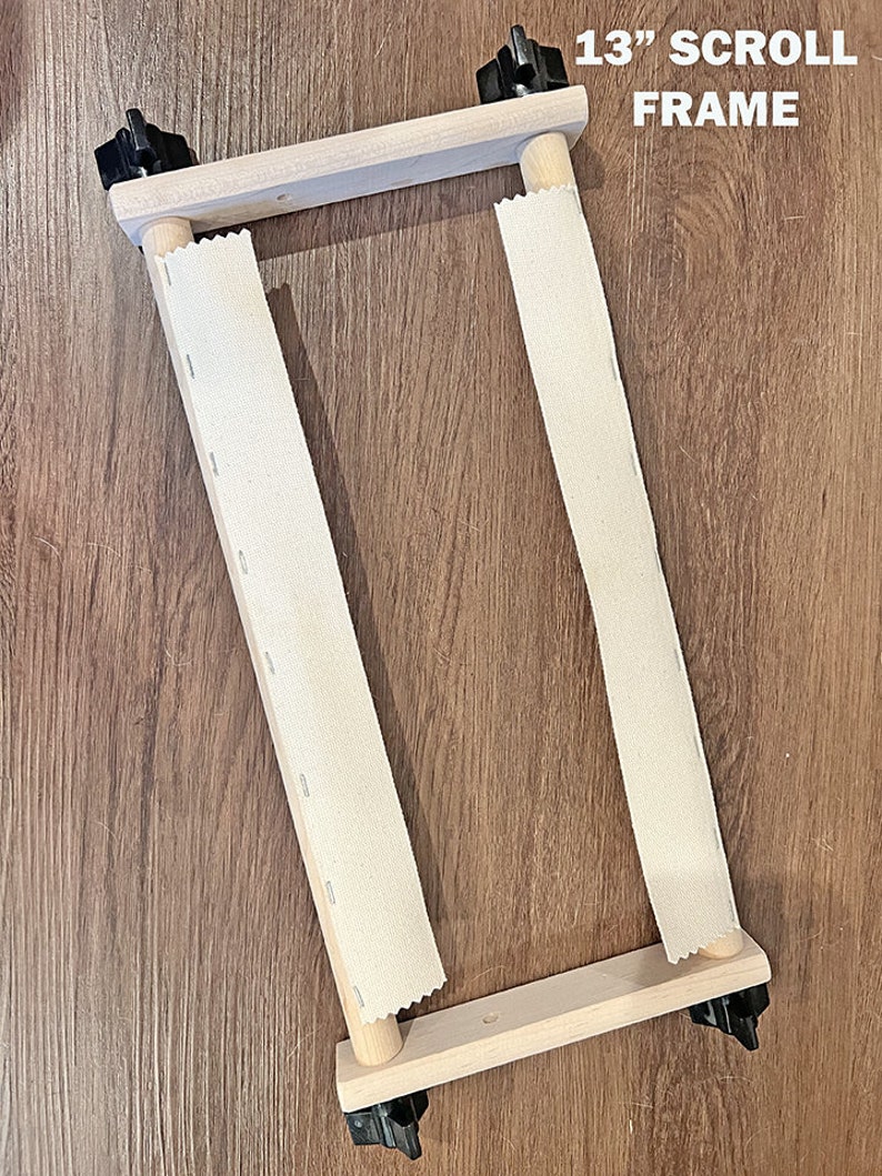 May include: A 13-inch wooden scroll frame with two white canvas rolls. The frame has black knobs on each corner.