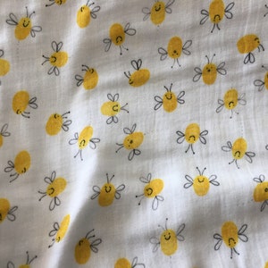 Pode incluir: Tecido branco com um padrão repetitivo de abelhas amarelas com contornos pretos e rostos sorridentes.