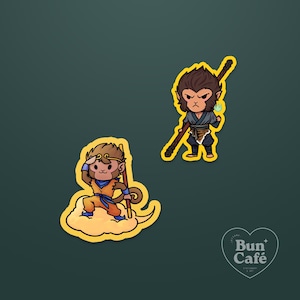 May include: Two stickers featuring cartoon monkey characters. One sticker shows a monkey on a cloud, wearing orange and blue clothing, and holding a staff. The other sticker depicts a monkey in a blue outfit, holding a staff and a glowing orb.