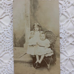 carte postale vintage photo sépia. Ancienne carte postale photographique d'enfants. Portrait d'un enfant et d'un bébé au début du XXe siècle.