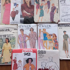 May include: A collection of vintage sewing patterns for clothing. The patterns are from different brands, including McCall's, Butterick, Simplicity, and New Look. The patterns feature a variety of styles, including dresses, tops, and trousers. The patterns are in various colours, including pink, blue, green, and yellow.