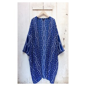 May include: A blue and white patterned kimono with a geometric design. The kimono has a wide, flowing silhouette and is perfect for layering over a simple outfit.