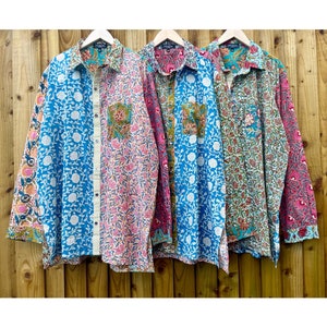 Puede incluir: Tres camisas de manga larga con estampado floral. Las camisas son en tonos de azul, rosa y verde. Las camisas tienen un frente abotonado y un bolsillo de parche en el pecho izquierdo.