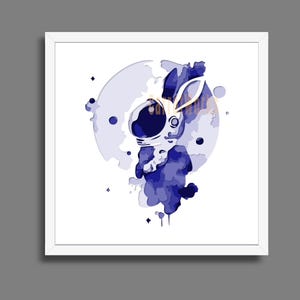 May include: Framed art print. A blue and white illustration of a rabbit wearing an astronaut helmet. The artwork has a watercolour effect with a moon and stars in the background. The rabbit is the central focus of the image.