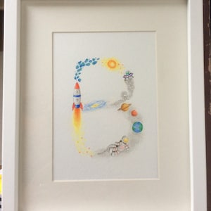 Pintura de letras com nome personalizado. Tema Espaço desenhado à mão, pintado em aquarelas. Emoldurado
