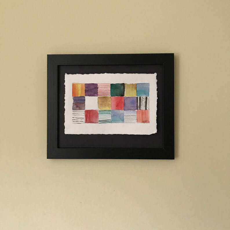 May include: A framed watercolor painting with a grid of 16 colorful squares. Each square has a different pattern, including stripes, dots, and lines. The painting is on a white background and is framed in a black frame.