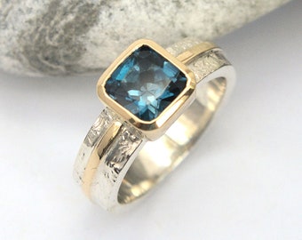 Anillo de oro y plata con topacio azul de Londres, engaste de bisel, banda con textura en espiral, tira de oro pulido en los hombros. HECHO A PEDIDO