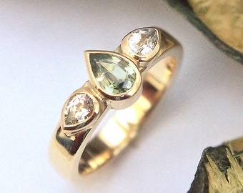 Anillo trilogía de zafiros verdes y blancos con engaste desgastado. HECHO POR ENCARGO.