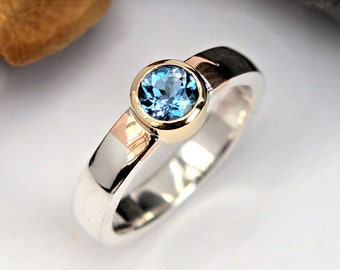 Anillo solitario de oro y plata con aguamarina, engaste de bisel de oro, banda pulida, detalles en oro rosa. HECHO A PEDIDO.