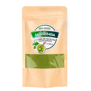 May include: A brown paper pouch with a clear window showing green moringa powder. The pouch has a label that says "100% Natural Zest Moringa Poudre de Feuilles Leaves Powder 150g".