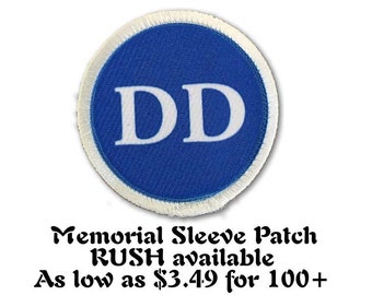 May include: A blue and white memorial sleeve patch with the letters "DD" in white on a blue circle. The text "Memorial Sleeve Patch RUSH available As low as $3.49 for 100+ " is below the patch.