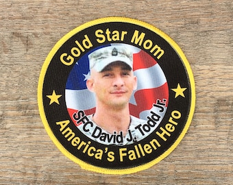 May include: A black and yellow embroidered patch with a photo of a soldier in uniform. The patch reads "Gold Star Mom, SFC David J. Todd Jr., America's Fallen Hero".