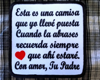 May include: White iron-on patch with black text that reads "Esta es una camisa que yo llevé puesta Cuando la abrases recuerda siempre que ahí estaré. Con amor, Tu Padre" and a red heart.