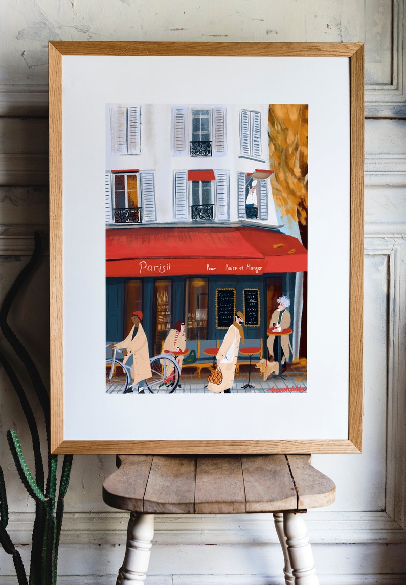 May include: A painting of a Parisian cafe with a red awning that says "Parisii pour boire et manger". There are people sitting outside the cafe and a person riding a bicycle.