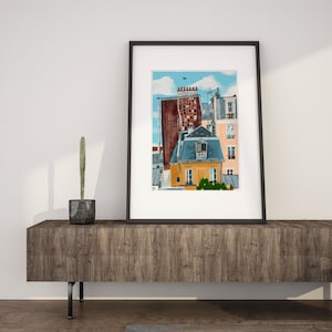 May include: A framed illustration of a Parisian cityscape with a blue sky and white clouds. The illustration features a brown building with a yellow building in front of it. The yellow building has a window with a balcony and a small tree in front of it.