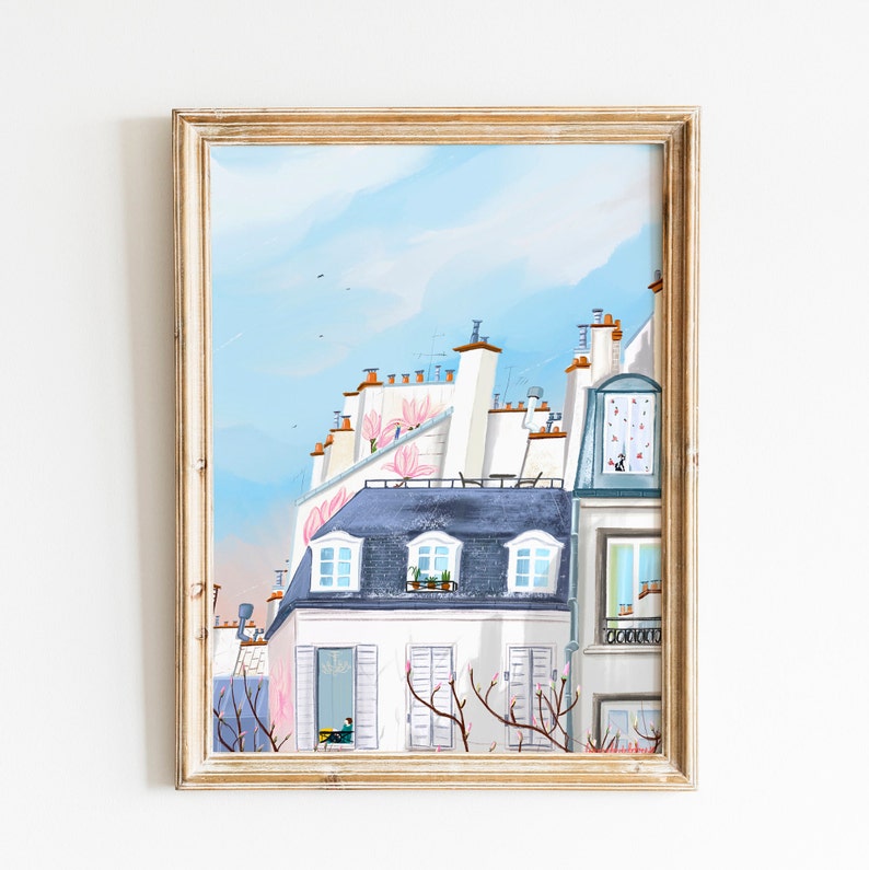 May include: A framed illustration of a Parisian cityscape with white buildings, blue roofs, and pink flowers. The illustration features a blue sky with white clouds and a glimpse of a person looking out a window.