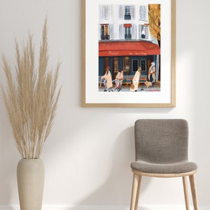 May include: A framed illustration of a Parisian street scene with a cafe called "Parisil" and people walking by. The cafe has a red awning and a sign that says "Pour boire et manger".
