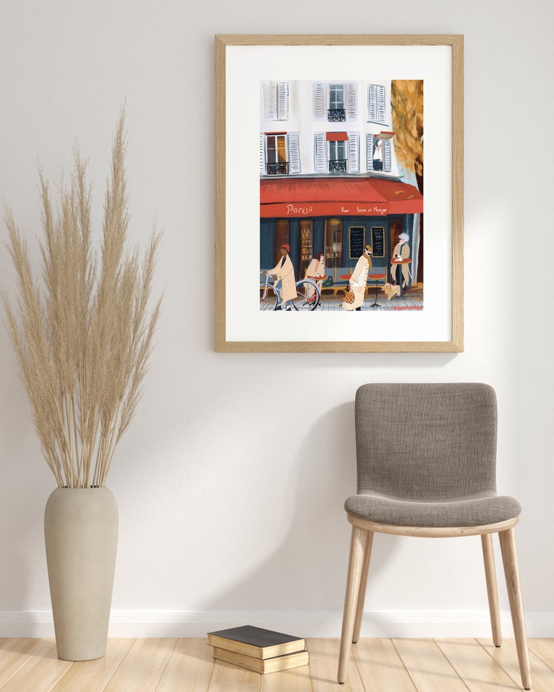 May include: A framed illustration of a Parisian street scene with a cafe called "Parisil" and people walking by. The cafe has a red awning and a sign that says "Pour boire et manger".