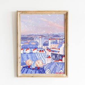Op de afbeelding: Een schilderij van een Parijse stadsgezicht met blauwe en witte daken en een roze lucht. Het schilderij is ingelijst in een licht houten lijst.