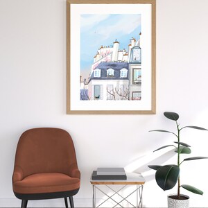 May include: A framed watercolor painting of a Parisian building with a blue sky and white clouds. The building has a pink roof and a window with a view of a tree.