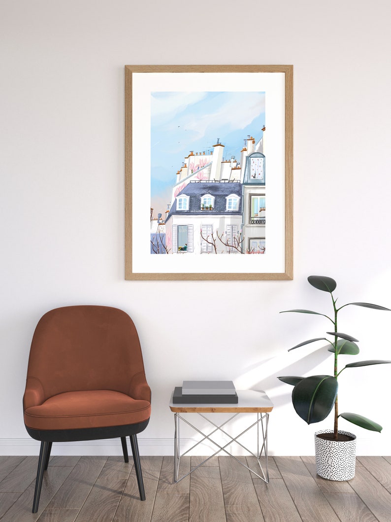 May include: A framed watercolor painting of a Parisian building with a blue sky and white clouds. The building has a pink roof and a window with a view of a tree.