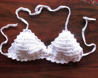 Puede incluir: Top de bikini blanco de ganchillo con tirantes ajustables. El top tiene un borde festoneado y una forma triangular.