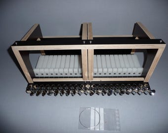 May include: A wooden soap cutter with a black top and a row of white dividers. The cutter has a series of silver-colored knobs along the bottom edge. A small bag with wire and other parts is included.