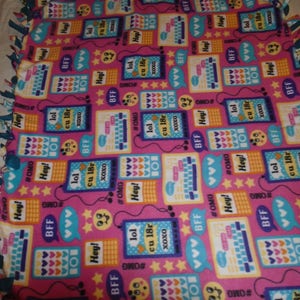 May include: Pink fleece tie blanket with a repeating pattern of colorful cell phones, hearts, stars, and text including "BFF", "lol", "cu 18r", "#OMG", and "Hey!"