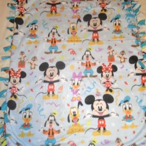 May include: A light blue fleece blanket featuring Mickey Mouse, Minnie Mouse, Donald Duck, Daisy Duck, Goofy, and Pluto. The blanket has a repeating pattern of the characters with colorful confetti and a knotted edge.
