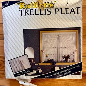 May include: A square product box for Rufflette Trellis Pleat curtain tape. The white box features black text, a large image of a window with white sheer curtains, and a smaller inset image showing the trellis pleat detail on white fabric.