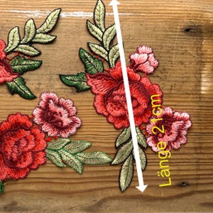 Könnte beinhalten: Rote, rosa und grüne gestickte Blumenapplikation mit einer Länge von 21 cm.  "Länge 21cm" ist in Gelb auf dem Bild geschrieben.