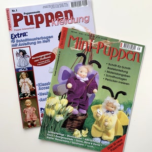 Könnte beinhalten: Zwei Magazine mit dem Titel "Puppen Kleidung" und "Mini-Puppen". Die Magazine zeigen bunte Illustrationen von Puppen und Puppenaccessoires. Der Text auf dem Cover der Magazine enthält Anleitungen zum Herstellen von Puppen und Puppenkleidung.