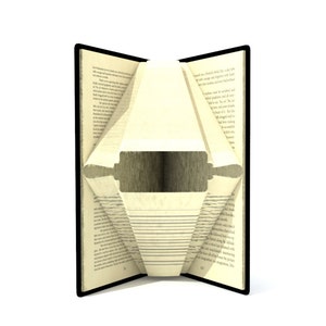 May include: An open book with pages folded to reveal a silhouette of a rolling pin. The book is open to a page with text.