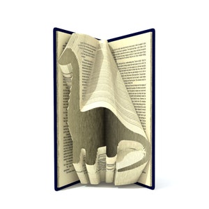 Könnte beinhalten: Ein Buch mit Seiten, die zu einer Vogelform gefaltet sind. Das Buch hat einen blauen Einband und die Seiten sind cremefarben.