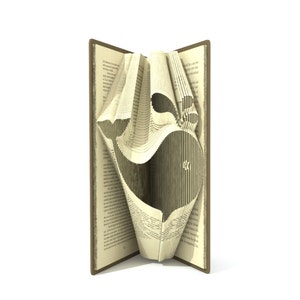 May include: A book with pages folded into a 3D design of a whale. The book is open and the whale is visible in the centre of the image.