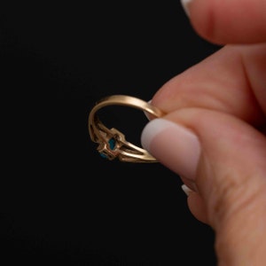 May include: A gold ring with a blue gemstone set in a decorative design.