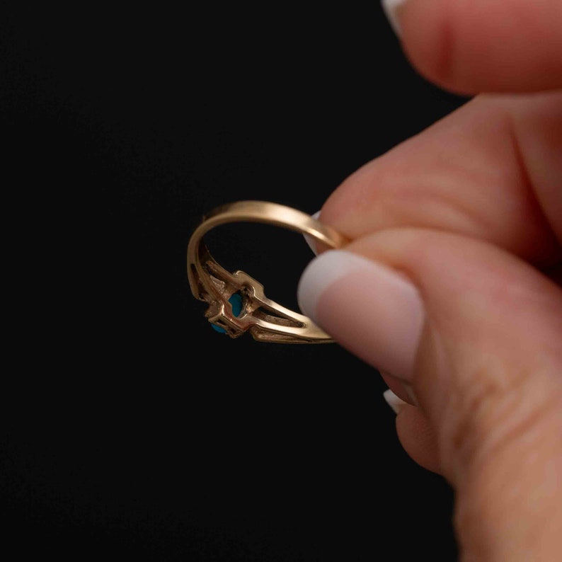 May include: A gold ring with a blue gemstone set in a decorative design.