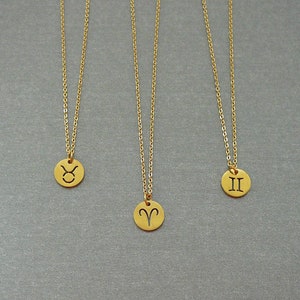 May include: Three gold necklaces with zodiac symbols on circular pendants. The pendants feature the symbols for Taurus, Aries, and Gemini.
