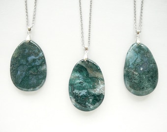 May include: Three silver chain necklaces with green agate stone pendants. Each pendant is a different shade of green with white and gray swirls.