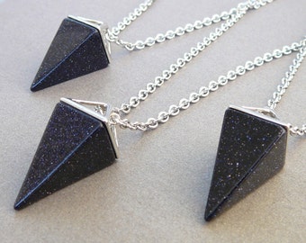 May include: Three silver chains with black gemstone pyramid pendants. The pyramids are faceted and have a sparkly finish.