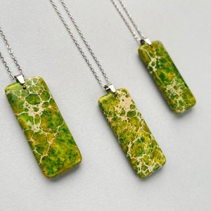 Puede incluir: Tres collares de plata con colgantes de piedra marmoleada verde y blanca. Los colgantes son rectangulares y tienen un patrón único.